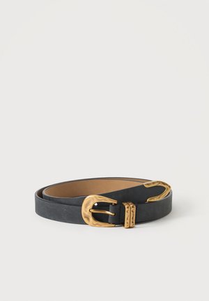 Ceinture en cuir noir enroulée avec une grande boucle en métal doré texturée et un passant de ceinture doré assorti sur un fond blanc.