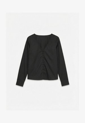 Zwarte blouse met lange mouwen, V-hals en met stof bedekte knopen aan de voorkant, platgelegd op een witte achtergrond.