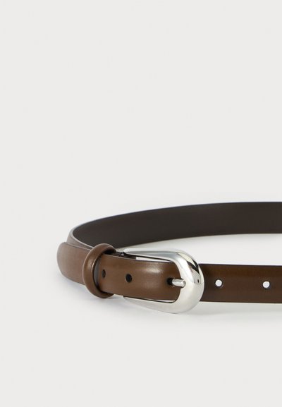 Ceinture en cuir marron avec une boucle ovale argentée brillante et plusieurs trous de réglage sur un fond blanc uni.