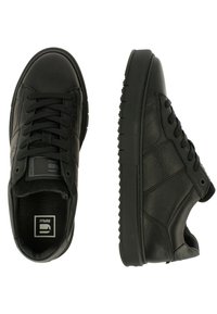 Baskets en cuir noir avec un bout arrondi, une tige texturée, une fermeture à lacets et une semelle extérieure en caoutchouc plate avec un motif antidérapant.