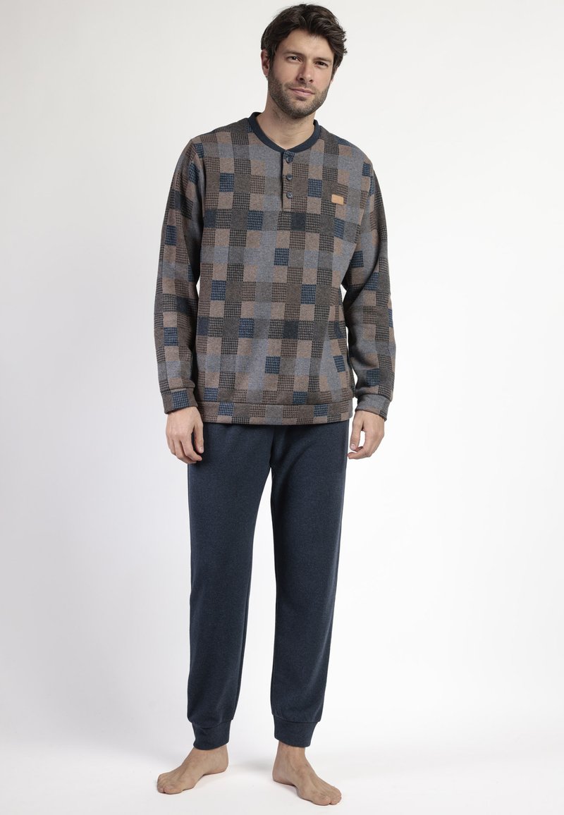 Camisa de manga larga en patrón a cuadros marrón, gris y azul con cuello henley. Joggers azul marino con puños elásticos y textura suave.