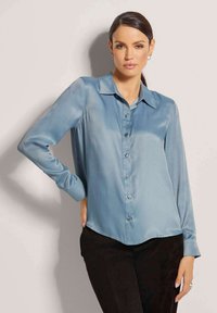 Satin blauwe overhemd met knopen, met een kraag, lange mouwen en een afgeronde onderkant. Beschikbaar met glanzende knopen en een gladde textuur.