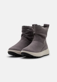 Bottes cheville en cuir gris doux avec un design décontracté, semelle en caoutchouc beige et dessus texturé. Caractérisées par un embout arrondi et un intérieur rembourré.