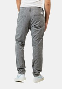 Gray, lightweight pants with a smooth texture, elastic waistband, and two back pockets. Worn with white sneakers featuring light blue accents.