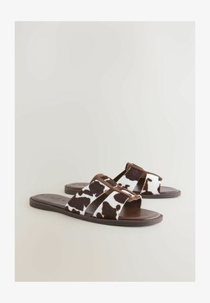 Natikače s kravjim vzorcem v rjavo-beh barvni kombinaciji, ravnim podplatom, odprto obutvijo in mehkimi materiali za udobje.