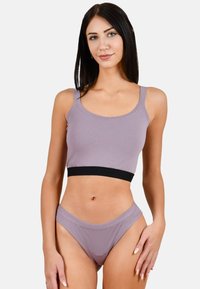 Lavendel geknipte tanktop met een zwarte band, gecombineerd met bijpassende lavendelkleurige bikini-broekjes. Zacht, rekbaar stof met een gladde textuur.