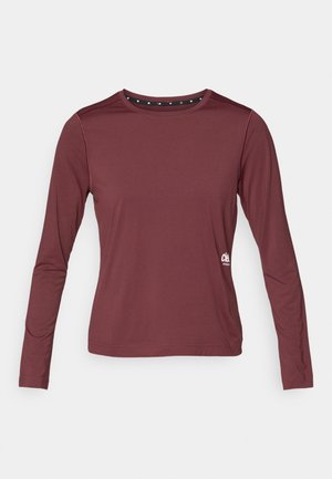 Bordeaux langærmet skjorte med rund halsudskæring. Glat stof med subtil stræk. Har en sort detalje ved kraven med hvide prikker.