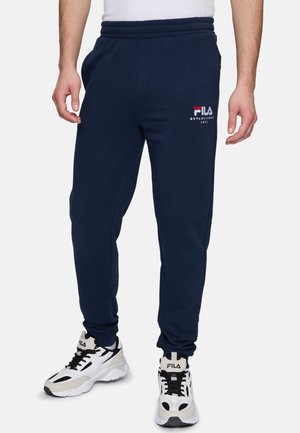 Navyblauwe joggingbroek met een elastische tailleband, zijzakken en geborduurd FILA-logo. Het materiaal lijkt zacht en geschikt voor casual gebruik.