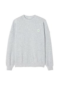 Felpa grigia chiara realizzata in tessuto morbido. Presenta un collo rotondo, maniche lunghe, polsini a costine e una piccola patch con il logo sul petto.