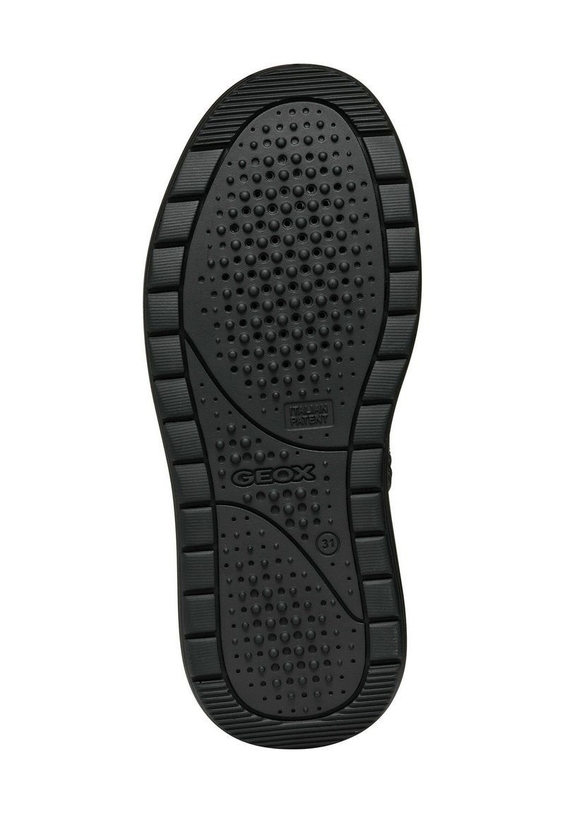 Schwarze Gummisohle mit strukturiertem Finish, das kleine kreisförmige und rechteckige Muster sowie ein auf der Unterseite gedrucktes Logo zeigt.