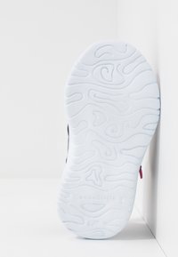 Bílá gumová podrážka s texturovaným vzorem ve spirále. Obsahuje embosované logo "KangaROOS". Čistý a hladký design zvýrazňuje přilnavost.