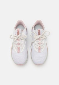 Baskets blanches avec des accents roses. Tige en maille, bout rond, lacets plats et semelle texturée. Marquage sur l'onglet du talon et la section des lacets.