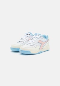Sneakers bianchi con un motivo perforato, dettagli azzurri e un logo rosa. Materiali texturizzati e colletto imbottito per il comfort.