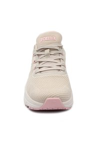Zapatilla atlética de color beige claro con una parte superior de malla texturizada, acentos rosa sutiles, cordones planos y una suela blanca robusta con una tapa de talón rosa.