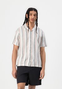 Short-sleeve button-up shirt in light fabric featuring vertical stripes in pink, gray, and white; paired with black shorts.