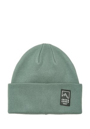 Groene geribbelde gebreide muts met omgeslagen rand en een zwart Jack & Jones-logo patch aan de voorkant.