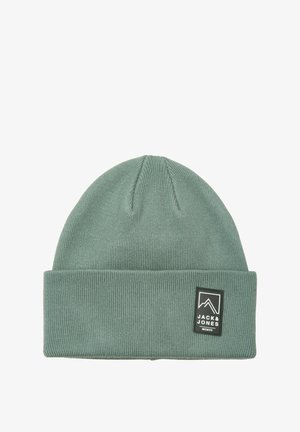 Groene geribbelde gebreide muts met omgeslagen rand en een zwart Jack & Jones-logo patch aan de voorkant.