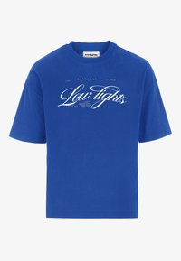 Modrá bavlněná tričko s volným střihem, zdobené bílým a zlatým písmem. Krátké rukávy a design s kulatým výstřihem, hladká textura.