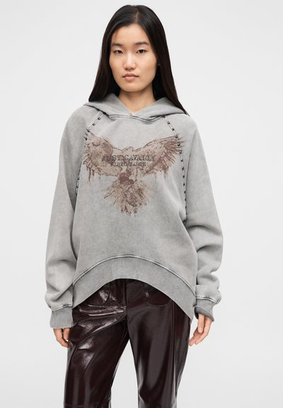 Szürke, túlméretezett kapucnis pulóver elülső részén sas grafikával és "Just Cavalli" felirattal, bordázott mandzsettákkal, húzózsinóros kapucnival és fém díszítőelemekkel.