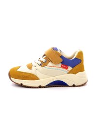 Sneaker met een crèmekleurige textielen bovenkant, bruine suède accenten, blauwe synthetische details, een klittenbandsluiting en een gestructureerde zool met multikleurige accenten.