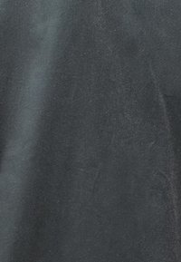 Μαύρος υφάσματος με απαλή, ελαφρώς υφητή επιφάνεια. Έχει ματ φινίρισμα και διακριτική λάμψη, υποδεικνύοντας ένα ομαλό, ποιοτικό υλικό.