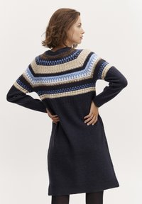 Robe en tricot avec des motifs géométriques multicolores au niveau de l'empiècement, corps bleu marine, manches longues et coupe décontractée, fabriquée en mélange de laine doux.
