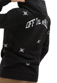 Svart huva med "OFF THE WALL" i vit text på baksidan och flera små vita dödskallegrafik på ärmarna och kroppen.