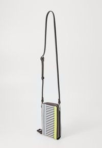 Crossbody torba s prugastim vzorom v mornarsko modri, beli in rumeni barvi. Ima zadrgo, črne usnjene detajle in nastavljiv trak.