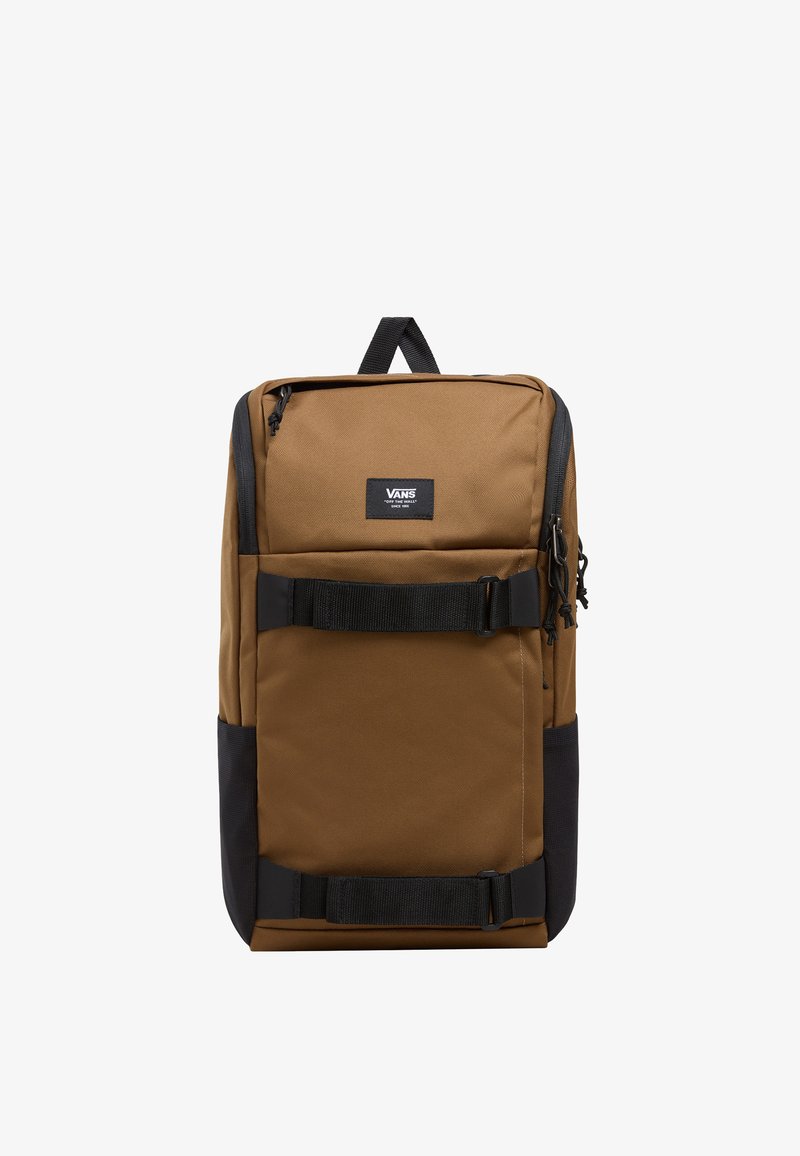 Brązowy plecak z płótna z czarnymi akcentami, z przednią kieszenią i regulowanymi paskami. Ma prostokątny kształt i logo Vans z przodu.