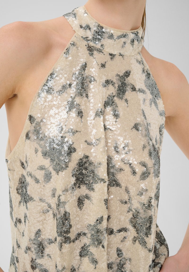 Beige, perlebesat ærmeløs top med høj krave, med et blomstermønster i grå og en løs pasform. Blød tekstur med glitrende detaljer.