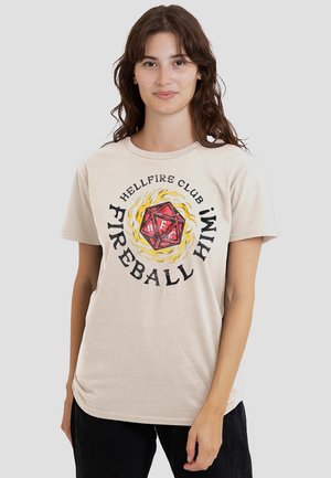 Beige Baumwoll-T-Shirt mit einem grafischen Design, das einen roten, 20-seitigen Würfel zeigt, umgeben von gelben Flammen und fettem schwarzen Text, der "HELLFIRE CLUB FIREBALL HIM" liest.