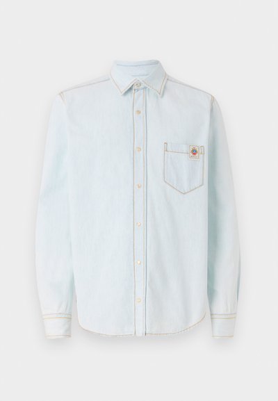Camicia azzurra a maniche lunghe in morbido tessuto denim, con colletto button-down, taschino sul petto e dettagli di cucitura a contrasto gialli.