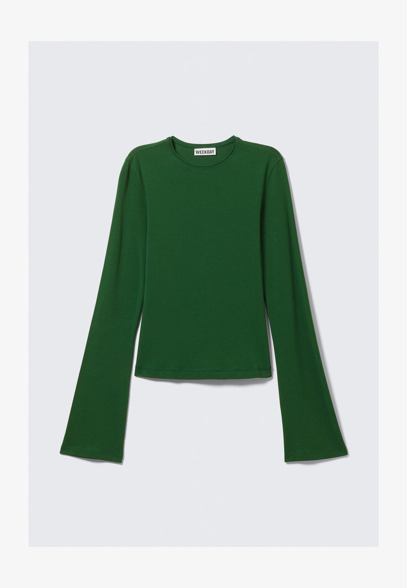 Haut à manches longues, de couleur vert profond, fabriqué en tissu doux ; présente un col rond et des manches évasées ; conception cropped avec une texture lisse.