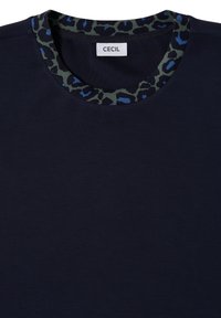 Chemise bleu marine à col rond avec un bord à imprimé léopard noir, vert et bleu et une étiquette blanche portant la mention "CECIL" à l’intérieur du col.