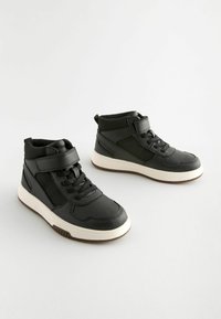 Zwarte hoge sneakers met een gladde leren afwerking, voorzien van veters, een klittenbandsluiting en een contrasterende witte zool. Geribbelde zijpanelen.