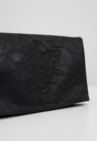 Portafoglio nero in pelle testurizzata con un motivo sottile, caratterizzato da un logo in rilievo, design pieghevole e bordi lisci.