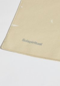 Tapete de tela color canela con textura suave, bordes cosidos y el texto "Scispiritual" impreso en gris claro.