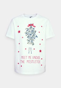 Vit bomulls-T-shirt med en mistelgröns-grafik med ett rött band, omgiven av rosa stjärnor, och texten "MÖT MIG UNDER MISTELTREN."