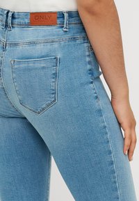 Lichtblauwe denim jeans met een slimfit ontwerp, met een achterzak, leren merklabel op de tailleband en een gladde textuur.