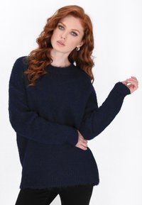 Navy-blauer oversized Pullover aus weichem, strukturiertem Stoff mit langen Ärmeln und gerippten Bündchen. Hat einen runden Halsausschnitt und eine lockere Passform.