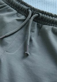 Shorts de jogging gri, cu un talie ajustabilă prin șnur, textură de țesătură netedă și un buzunar aplicat pe lateral.