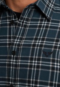 Flanellen overhemd in donker teal met een wit en zwart ruitpatroon, voorzien van een klein geborduurd logo en een klassieke knoopsluiting.