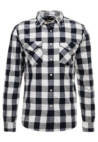 Camicia a maniche lunghe a quadri bianco e nero realizzata in tessuto con una finitura superficiale testurizzata; presenta due tasche sul petto e chiusura con bottoni.