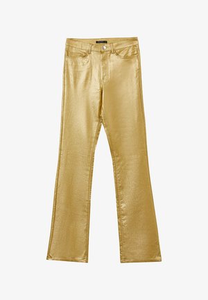 Jean évasé en or métallique avec une texture lisse et brillante. Présente des poches avant, une fermeture éclair et une taille standard.
