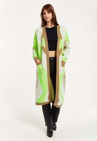 Long cardigan with a green and beige abstract pattern, made of textured knit fabric. Features open front, two front pockets, and ribbed cuffs.