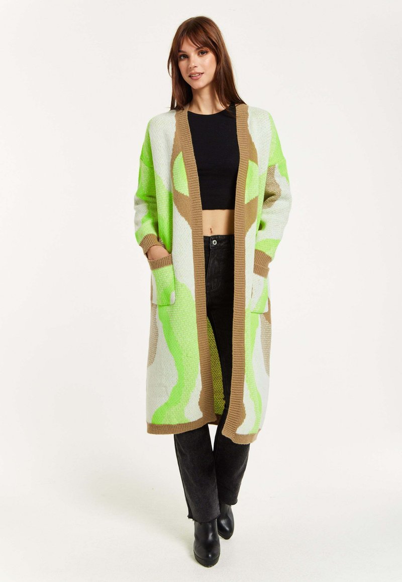 Long cardigan with a green and beige abstract pattern, made of textured knit fabric. Features open front, two front pockets, and ribbed cuffs.