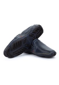 Marineblaue Slipper aus perforiertem Lederobermaterial, mit kontrastierenden Nähten und einer strukturierten Gummisohle, die für Flexibilität und Grip ausgelegt ist.