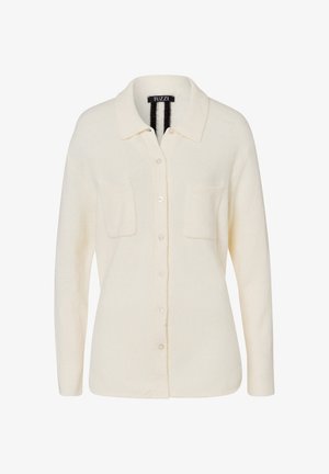Cream-colored cardigan made of soft fabric, featuring a collared neckline, button closure, and two chest pockets.