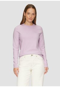 Lichtpaars lange mouwen trui met een ronde hals, gemaakt van zacht materiaal, gecombineerd met witte jeans, frontaal zicht. Eenvoudig ontwerp, geen patronen.
