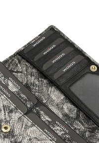 Černá a stříbrná peněženka s texturovaným hadím vzorem, sloty na kreditní karty označené "wojas" a zlaté zapínání na patentku.